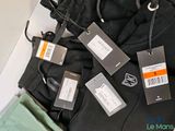 many luggage tags attached to a backpack on a table