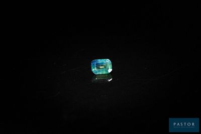 une pierre bleue et verte posée sur une surface noire