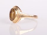 a close up of a gold ring with a tiger eye stone