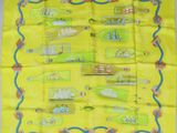 une écharpe jaune sur laquelle est représenté un motif de bateaux dans des bouteilles