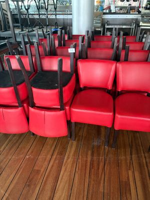 many red chairs in a row on a wooden floor