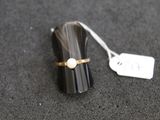 un petit objet noir orné d'un anneau en nacre