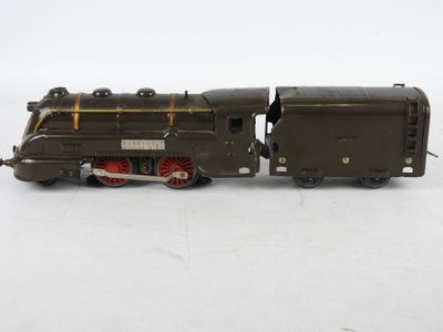 une vieille locomotive miniature posée sur une surface blanche