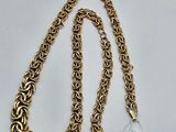 a close up of a gold chain with a tag on it