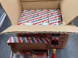 une boîte en carton remplie de piles de différents types, posée par terre