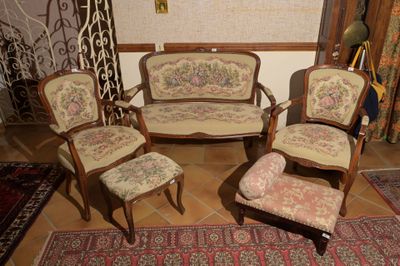 quatre chaises et un canapé dans une pièce recouverte d'un tapis
