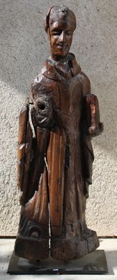 wooden statue of a man holding a dog on a marble base