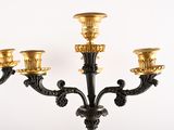 a black and gold candelier with three candles on it