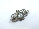 a close up of a broochle with a blue stone in it