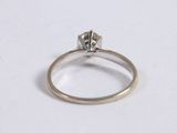 a close up of a diamond ring on a white surface
