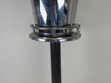 a close up of a silver vase on a black metal stand