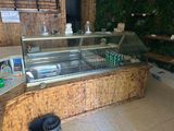 a display case in a restaurant with a lot of food on the counter