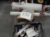 un sac posé par terre, contenant tout un tas d'objets