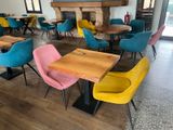 brightly colored chairs and tables in a restaurant with a fireplace in the background