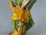 a figurine of a woman holding a basket of flowers