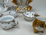 a lot of small cups and saucers sitting on a table