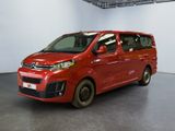 La camionnette rouge est garée dans une grande pièce au sol noir.