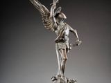 a bronze statue of a woman holding a bird on top of a pedestal