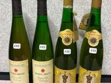 quatre bouteilles de vin sont alignées sur un plan de travail