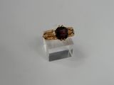 an image of a gold ring with a garnet stone on it