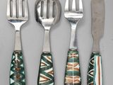 three forks and a knife are sitting next to each other on a table