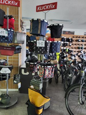 de nombreux vélos dans un magasin où sont accrochés de nombreux sacs au mur