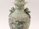 a large vase with a lid and a bird on it