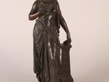 une statue en bronze représentant une femme tenant un vase