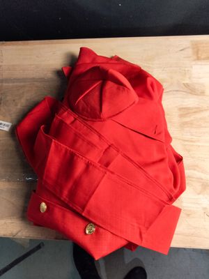 une personne assise à une table, vêtue d'une veste rouge