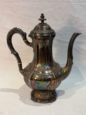 silver plated coffee pot with ornate handle on white background
