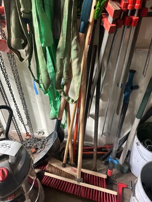 un tas de balais et d'autres outils dans un garage
