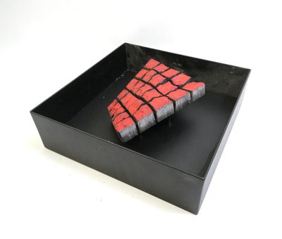 a black box with a red and black piece of cake in it