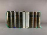 several books are lined up in a row on a gray surface