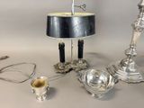 a silver table with a lamp and a silver cup on it