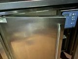 a stainless steel refrigerator in a kitchen with a red basket on top of it