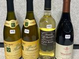 quatre bouteilles de vin sont alignées sur un plan de travail