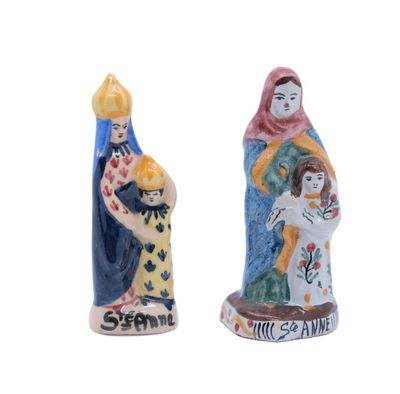 deux figurines représentant une femme et un homme tenant un enfant dans leurs bras