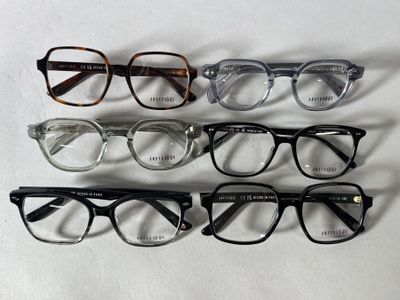 quatre paires de lunettes sont alignées sur une surface blanche
