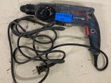 a corded drill on the floor next to a corded cord