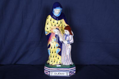 figurine représentant une femme tenant un enfant dans ses bras, sur fond bleu