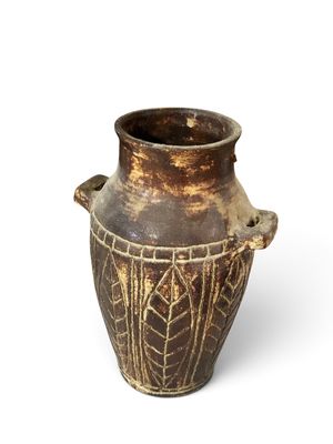 a brown vase that is sitting on a white surface