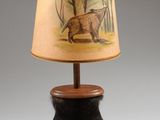 une photo d'une lampe de table sur laquelle est posé un ours