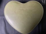 an image of a heart shaped purse sitting on top of a black cloth