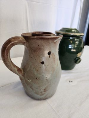 two vases sitting on a table with a white table cloth