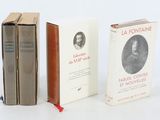 trois livres posés l'un à côté de l'autre sur une surface blanche