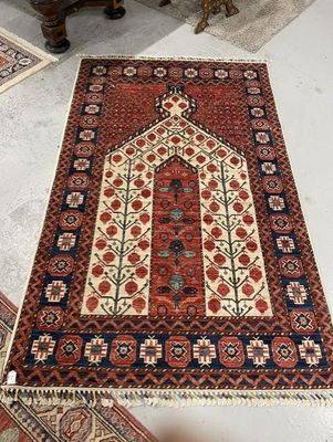 un tapis rouge et bleu posé sur un sol blanc, à côté d'une chaise