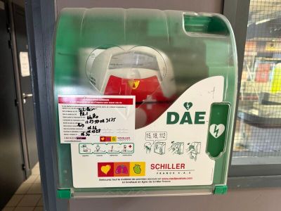 une boîte verte et blanche sur laquelle figure une borne d'incendie rouge