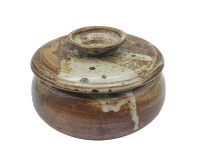 a brown pot with a lid sitting on a white surface