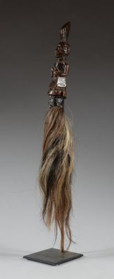 sculpture représentant la tête d'une femme posée sur un socle, avec de longs cheveux