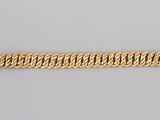 a close up of a gold bracelet on a white surface